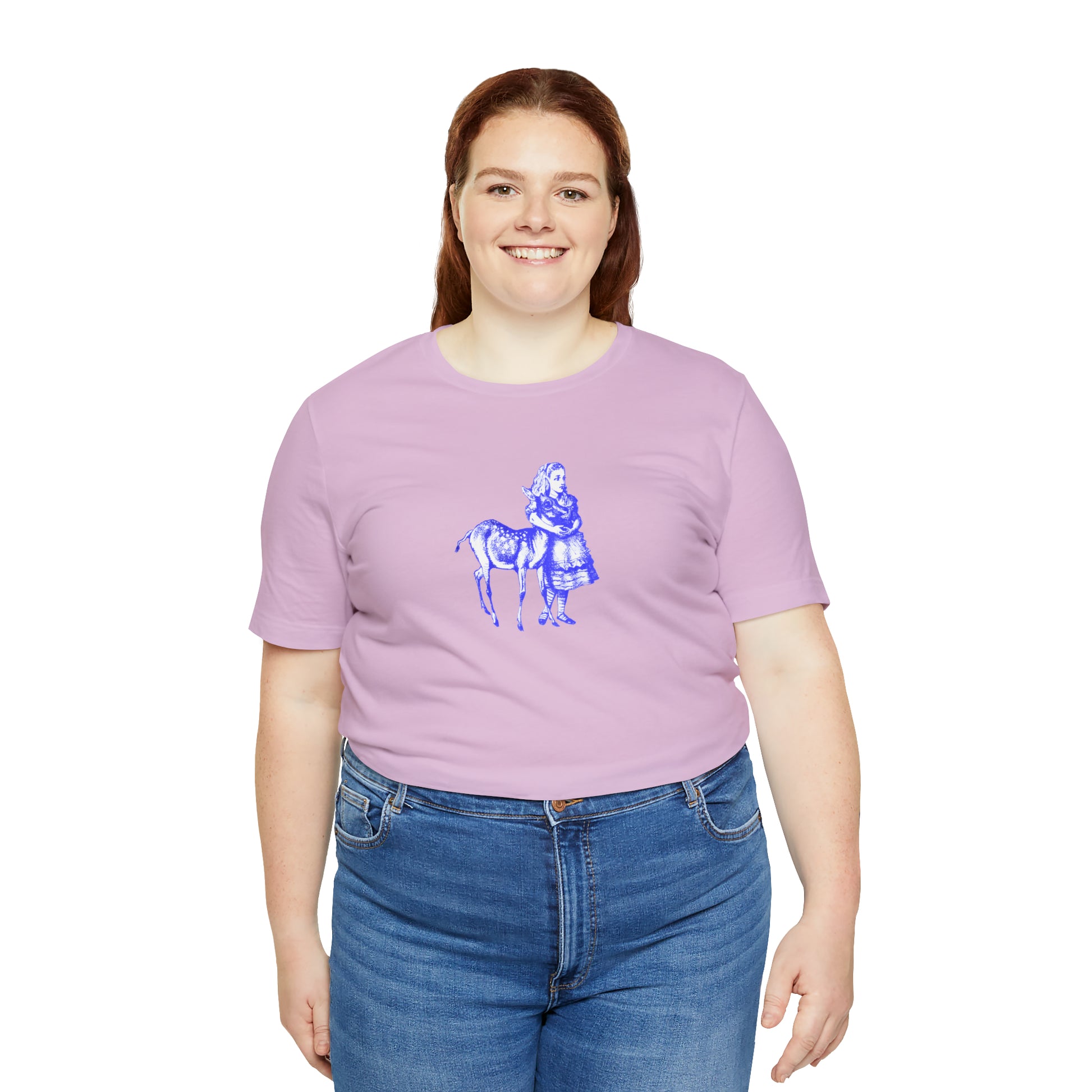 A smiling plus sized woman wearing a light purple t-shirt with an illustration of Alice in Wonderland and a baby deer printed in blue.