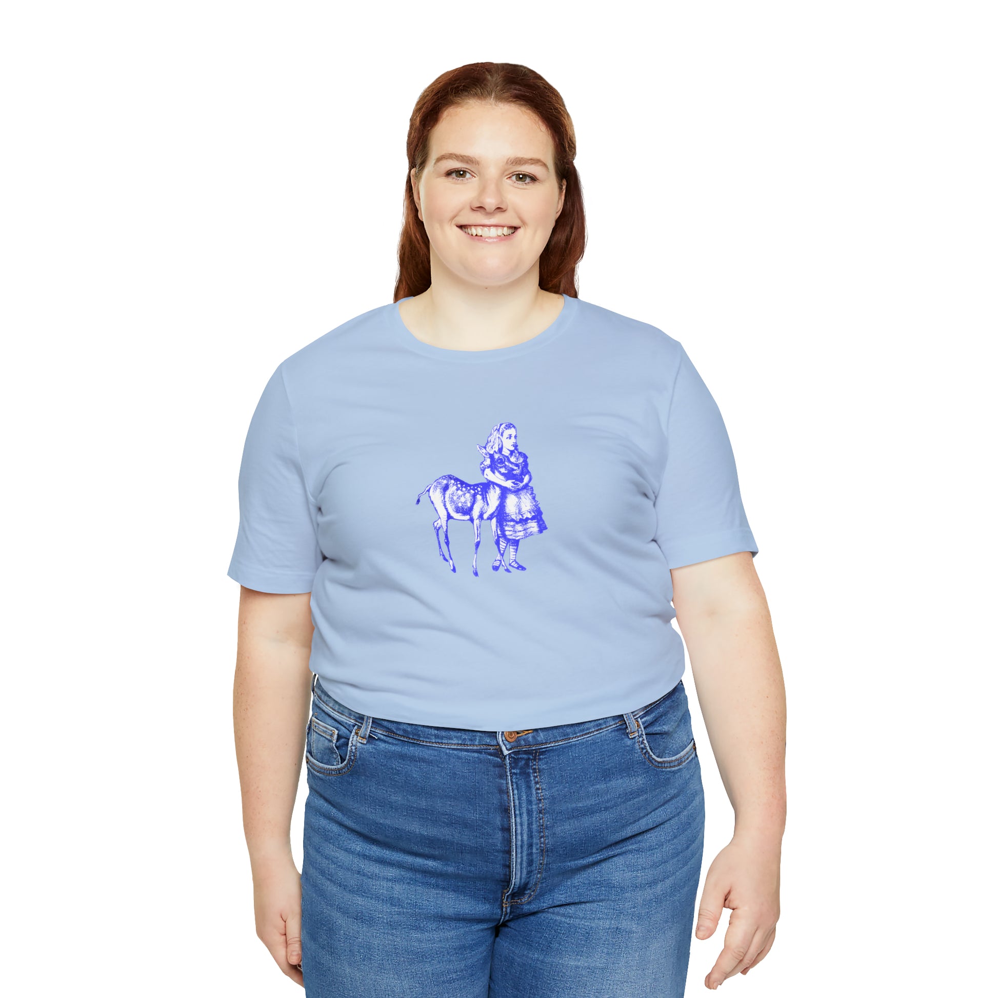 A smiling plus sized woman wearing a blue t-shirt with an illustration of Alice in Wonderland and a baby deer printed in blue.