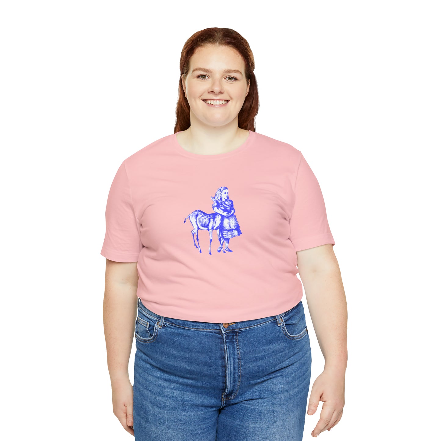 A smiling plus sized woman wearing a pink t-shirt with an illustration of Alice in Wonderland and a baby deer printed in blue.