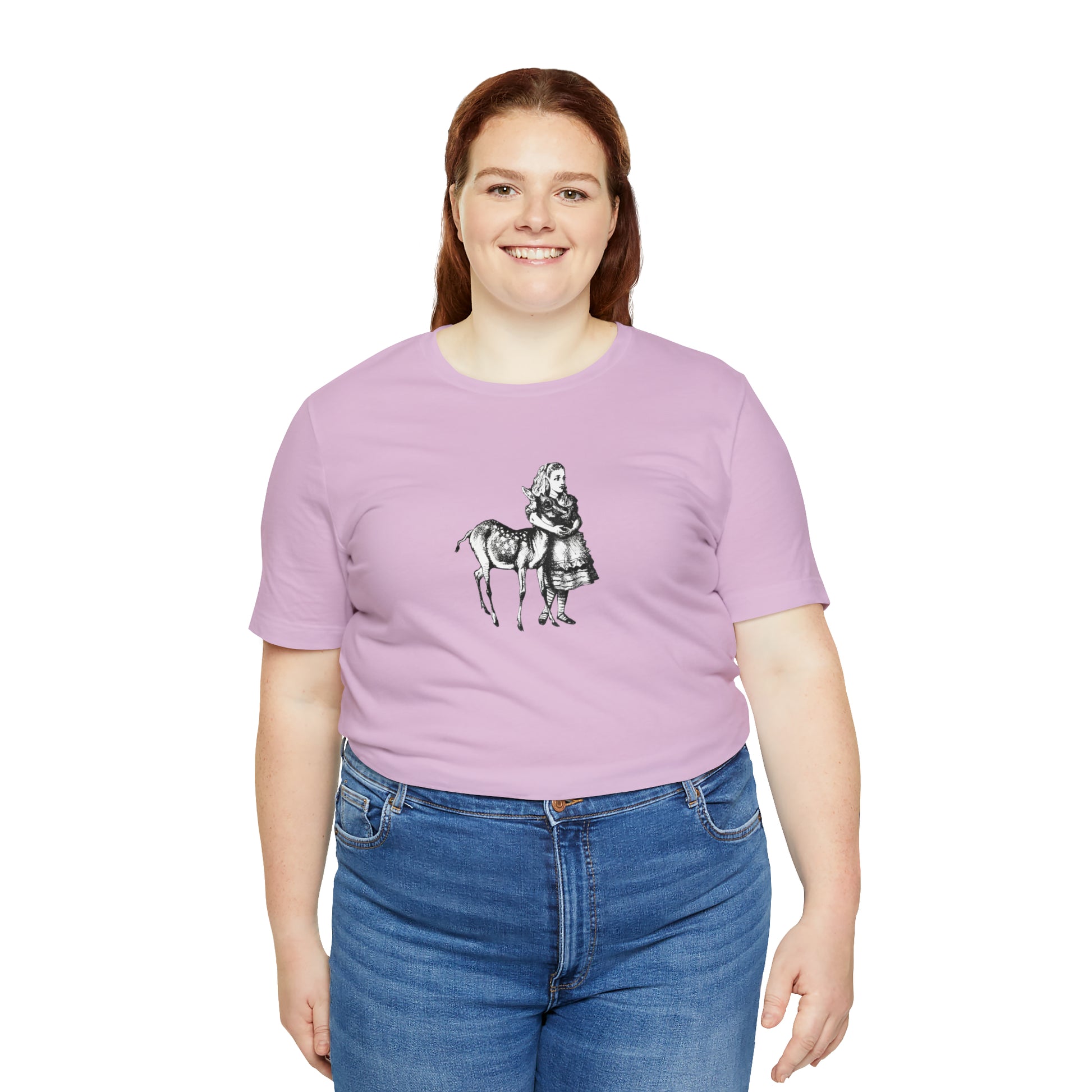 A smiling plus sized woman wearing a light purple t-shirt with an illustration of Alice in Wonderland and a baby deer printed in black.